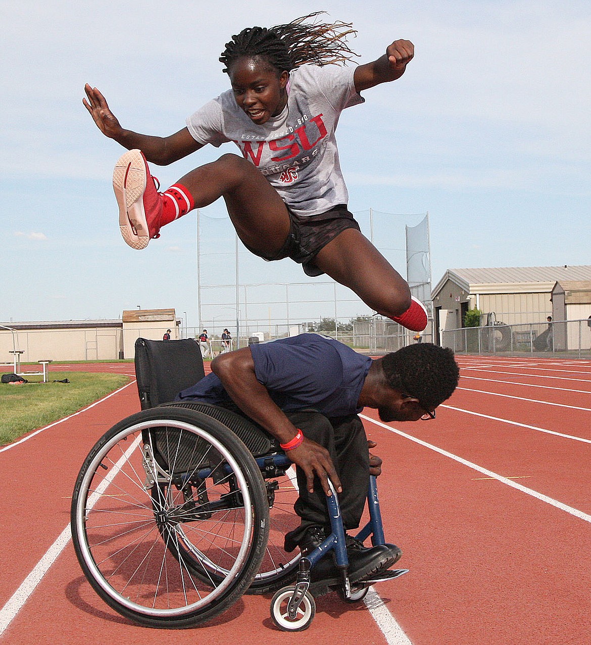Moses Lake foreign exchange student Abraham Massalay, wheelchair, asked teammate Obi Abonyi to test her skills hurdling him. She&#146;s got skills, he said.