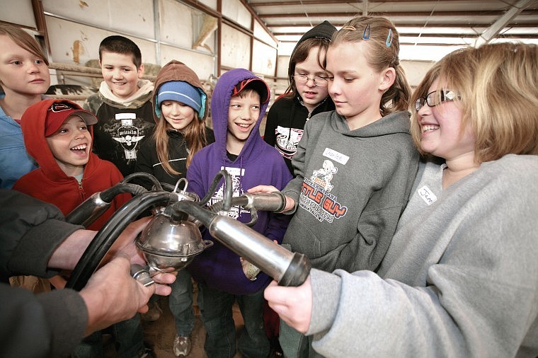 (Left to right) Polson students Meghan Gambrel, Justice Jones, Tristan Cardenas, Malia Seeley, Cameron Rinke-Brown, Karissa Maxfield, Charlee Cote and Jennifer Esquivel experience the strange sensation of a milking machine around their thumbs Thursday at the Annual Fourth Grade Agriculture Days.