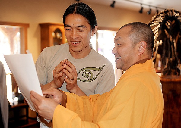 Artist Sunti Pichetchaiyakul, left, and Thay Linh Dat from Michigan share a laugh before the blessing ceremony Tuesday morning in Bigfork. The sculpture is on its way to the Linhson Temple in Belmont, Mich.