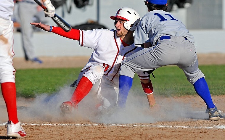 Kalispell Lakers&#146; Mike O&#146;Connell slides home safely as Zach Watson of Libby goes for the tag in the fourth inning of Wednesday evening&#146;s American Legion baseball game in Kalispell. O&#146;Connell scored the final run in a five-run inning.