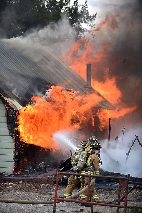 &lt;p&gt;Firefighters battle flames enveloping a house on Thursday afternoon, May 14, on Brunner Road southwest of Columbia Falls. (Brenda Ahearn/Daily Inter Lake)&lt;/p&gt;