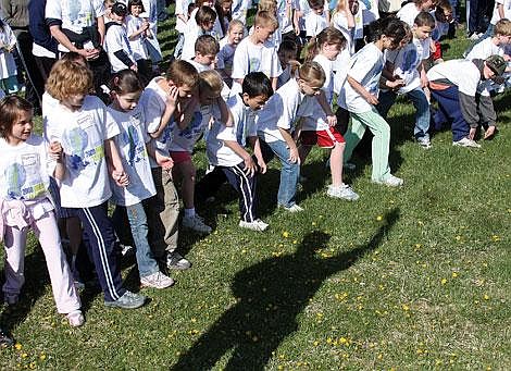 Photo by Aaric Bryan The shadow of St. Regis Principal Don Almquist is reflected on the ground in front of the group of kindergartners through fourth-graders, waiting for Almquist to fire the starting gun.