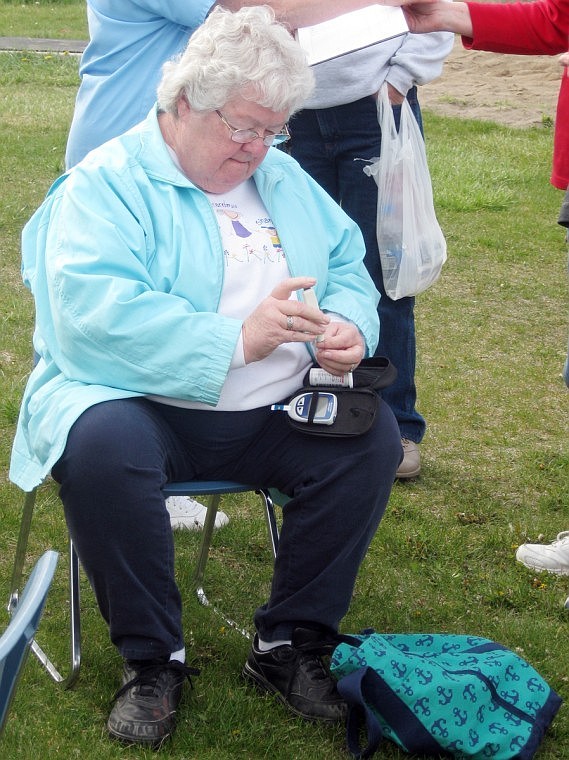 Amy Mickelson checks her blood sugar levels as part of the walking event on Monday.