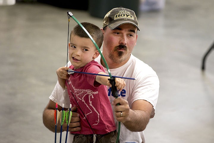 &lt;p&gt;JAKE PARRISH/Press Connor Kenyon, 4, is helped by his father Mike as he aims up his shot with a bow on Saturday at the archery exhibit at the Northwest Spring Fest at the Kootenai County Fairgrounds. The Fest continues Sunday, with more than 100 vendors, exhibits and performances.&lt;/p&gt;