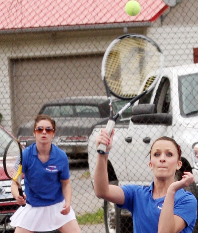 Alicia Scofield (left) knocks the ball back to the other side of the net while partner Hilary Stevens looks on.
