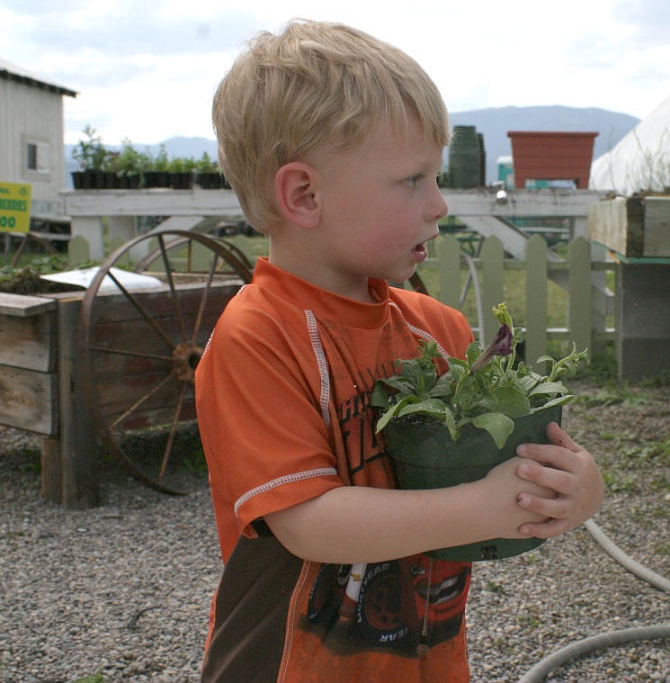 &lt;p&gt;Syris holds a flower during the Lynch Creek Nursery's Mother's Day event on both Friday and Saturday where kids were able to plant flowers for their mothers.&lt;/p&gt;