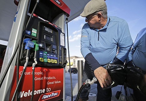 &lt;p&gt;In this Dec. 11, 2014 photo, Eduardo Palacios-Paez, of Miami, pumps gas at a RaceTrac gasoline station in Hialeah, Fla. Consumers have been uncharacteristically frugal, even as the country added jobs and a sharp drop in gas prices over the past year left them more money to spend.&lt;/p&gt;