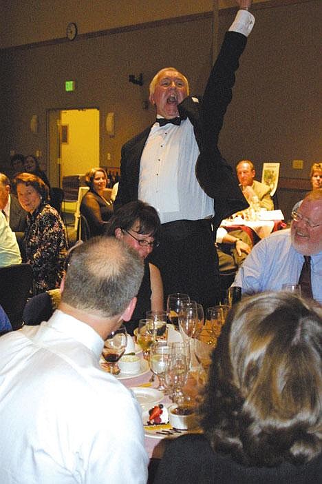 Craig Dorsing assists auctioneer Chuck Yarboro Jr. during the live auction portion of Cellarbration, a fund-raiser for the Big Bend Community College Foundation Saturday night.<br>Erin Stuber/Columbia Basin Herald