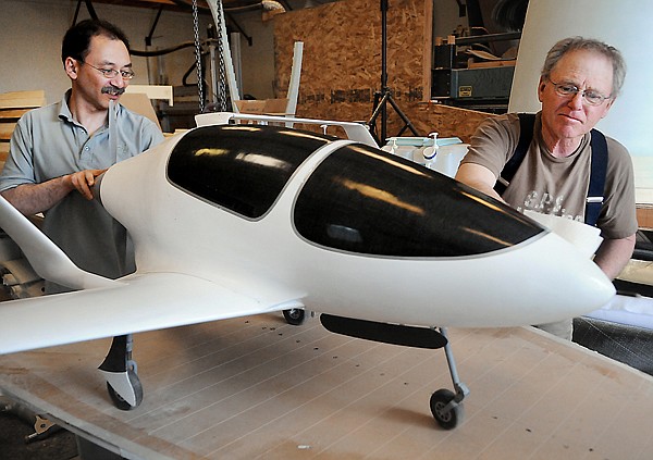 John McGinnis, left, and his father Pat McGinnis dust off and clean the one quarter scale model of the Synergy aircraft on at their shop in Kalispell.