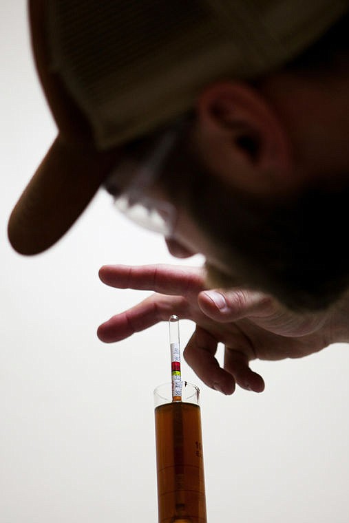 <p>Cole uses a hydrometer to check the original gravity of the liquid mash of grains, called the wort. Original and final gravity measures the density of the liquid before the yeast is added and after fermentation is complete and is used to determine the alcohol by volume of the final product. the May 15, 2014 in Kalispell, Montana. (Patrick Cote/Daily Inter Lake)</p>