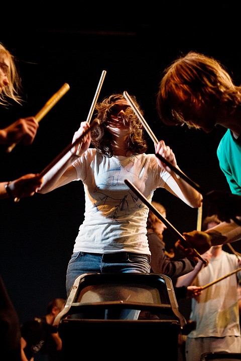 <p>MaryEllen Rose-Witt plays percussion with drum sticks on a chair back during a workshop with Dancers, Drummers, Dreamers.</p>