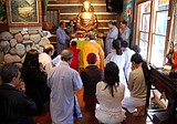 Monk blesses Buddha sculpture at gallery ceremony