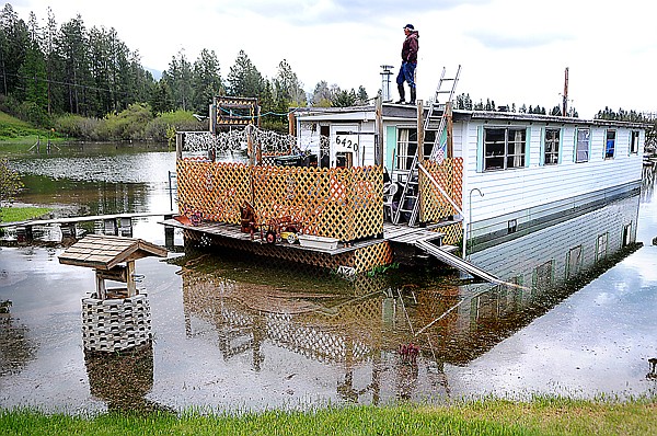 Stansberry climbs to the roof of his home to survey the flood waters. Floods are a regular occurrence for Stansberry, who has lived there for the past 40 years.