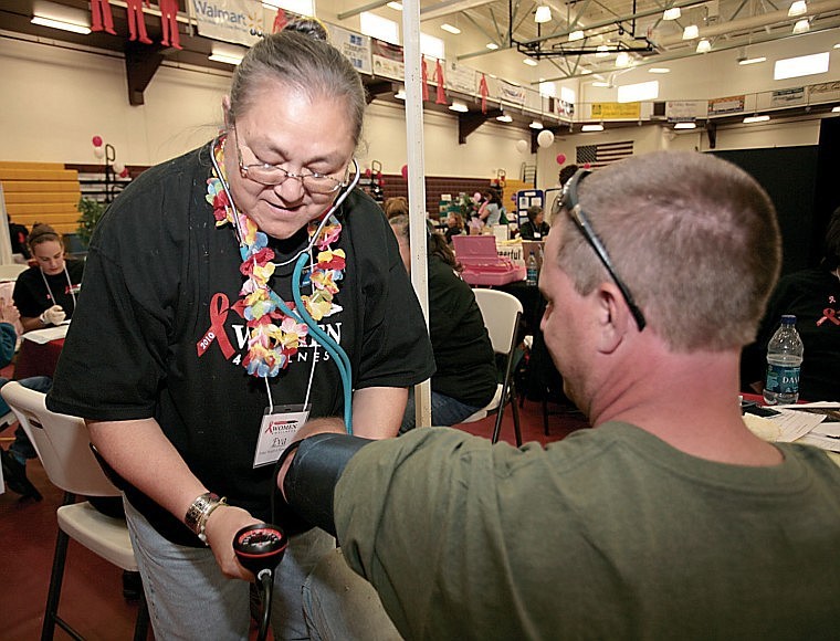 Evan Anderson, with Tribal Health and Human Services, performs a free blood pressure screening Thursday at the Women 4 Wellness event at SKC.