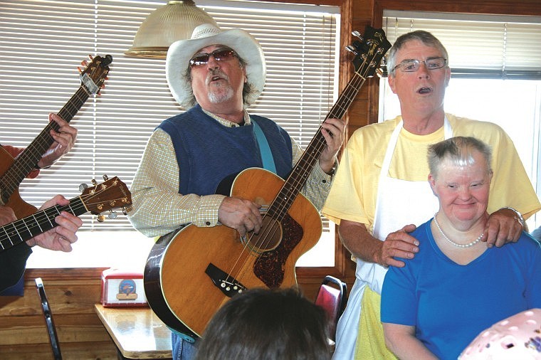 Burt Cannon (yellow shirt) and Sandra Brickzin sing along with the Singing Sons of Beaches during a party last Sunday at Ronan Pizza Cafe.