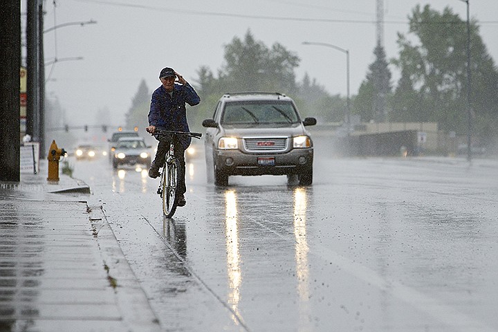 &lt;p&gt;JEROME A. POLLOS/Press Brad Bakie navigates his bicycle through a rain storm in Coeur d'Alene along Government Way as he pedals his way to the store Monday.&lt;/p&gt;