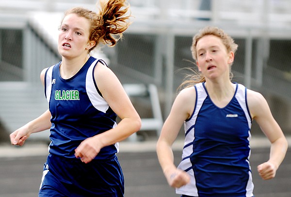 Glacier's Anna Delaray, left, pulls ahead to win the girls 800 on Friday afternoon at the 2011 Western AA Divisional Track meet in Kalispell. Teammate Heather Fraley (right) finished a close second.