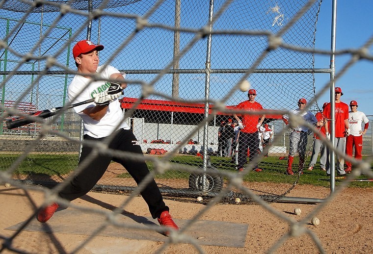 Kalispell Laker Brady Mott swings at an incoming ball as his teammates look on during a practice in late April.