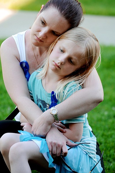 <p>Kari Brown of Kalispell holds her 7-year-old daughter Chloe as the two pause during a moment of remembrance at the Peace Officers Memorial Day event in Kalispell on Tuesday outside the Flathead County Justice Center. Brown is the daughter of Trooper Steve Frink of the Washington State Patrol. He was killed in the line of duty in 1993.</p>