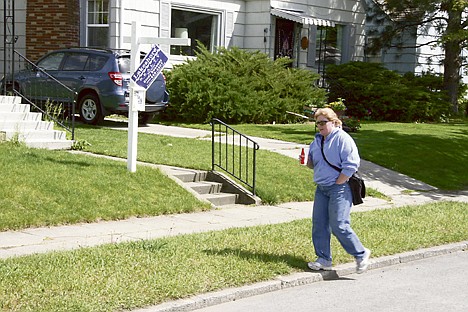 &lt;p&gt;Charlene Kunka walks by a house for sale in Coeur d'Alene on Friday. With interest rates still at record lows, buying a home or a car or refinancing an existing mortgage makes sense for many.&lt;/p&gt;