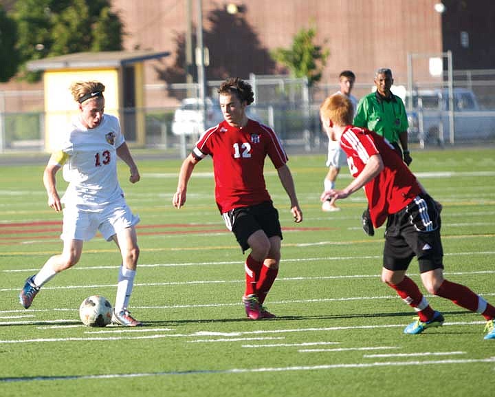 Sean Cotton (13) dribbles past Austin Cassity (12) and Riley Brannon (22). Moses Lake lost to Camas, 3-2.