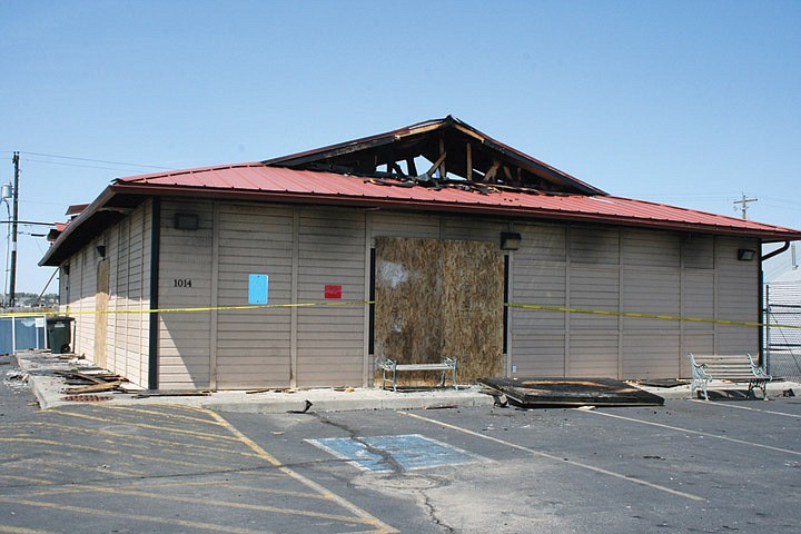The collapsed roof and boarded windows are evidence of the fire that destroyed Real Deals home decor Thursday night.