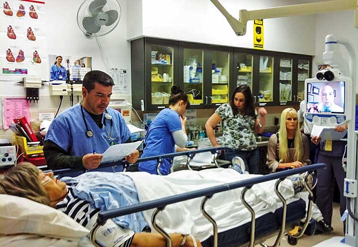 A stroke "patient" and the Quincy Valley Medical Center treatment team consult with a doctor via television during training for the telestroke system.