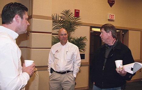 &lt;p&gt;Dave Knoll, right, talks with Mark Bottles, left, and Kent Corbett of Corbett Bottles Real Estate Auctions after buying 40 acres of land in Athol at an auction of bank-owned properties Friday at the Coeur d'Alene Resort.&lt;/p&gt;