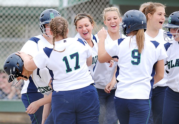 Brittany Franklin (left) pushes her way through her huddled teammates as she crosses home plate after hitting a two-run home run during the first inning of Tuesday&#146;s Western AA play-in game against Flathead at Kidsports Complex.