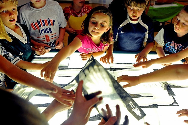 Edgerton Second Grader Delaney Ogle reaches out to grab an x-ray strip as her classmates reach out to grab other x-rays of bones as part of the University of Montana's spectrUM Discovery Area's Hands on Health exhibition Tuesday morning. The organization, which travels the state with a mobile science center, had yesterday's exhibition sponsored by the Blue Cross and Blue Shield of Montana, the Western Montana Area Health Education Center, Kalispell Regional Medical Center, and Edgerton School.