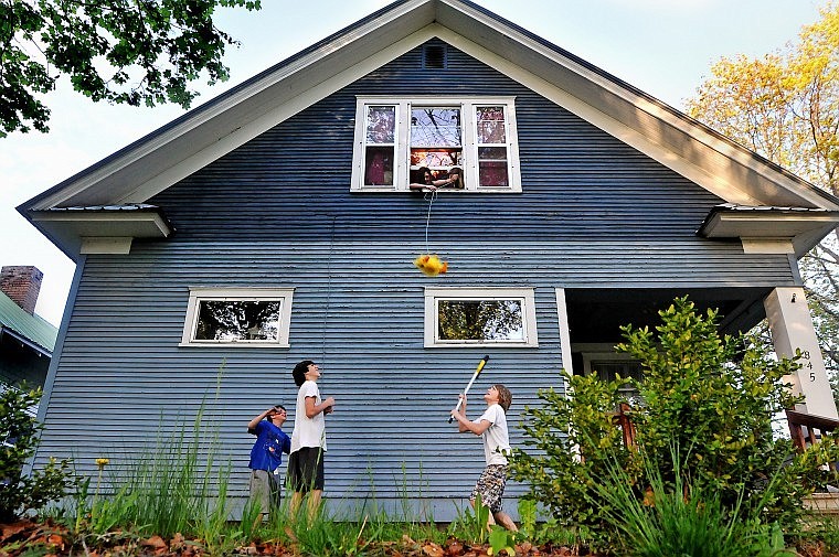 Colby Lorch, 14, prepares to swing at a stuffed animal dangled by Savannah Fraleigh and Julia Thompson while brothers Beau and Maxwell Fraleigh look on Wednesday evening in Kalispell.