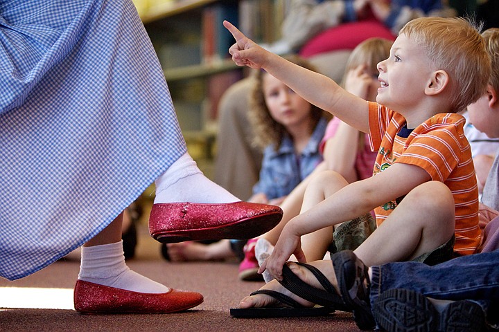 &lt;p&gt;JEROME A. POLLOS/Press Hunter Kline, 4, points to the illustrations in the &quot;Wizard of Oz&quot; book during a reading Wednesday at the Community Library Network in Hayden. Jessi Little, who plays Dorothy in the Coeur d'Alene Summer Theatre production of the classic story, read the book to an audience of children while wearing the iconic blue and white checkered dress and ruby slippers.&lt;/p&gt;