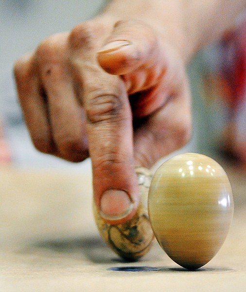 Erich Jonas, creator of the Egg Game spins one egg and prepares another as part of his demonstration of the game on Tuesday night at FVCC.