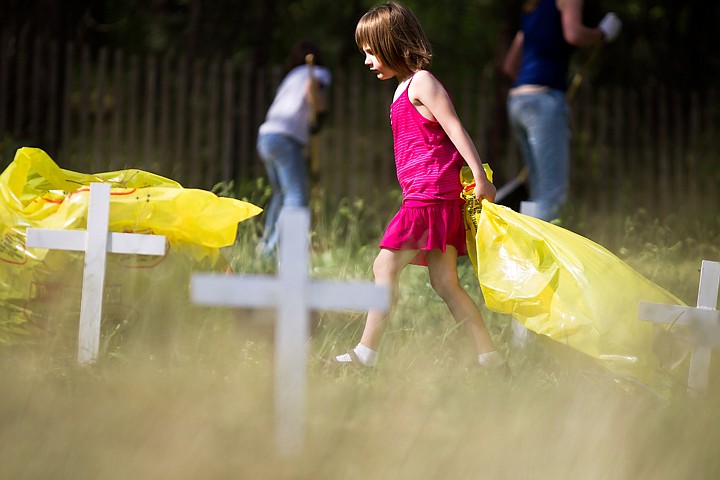 &lt;p&gt;SHAWN GUST/Press Silvia Klaeui, 5, drags a plastic bag through the Kootenai County Cemetery Monday while the Pine Tree 4-H Club gather for their annual clean-up effort. The group, who restored the cemetery in 1976, has been maintaining the site ever since. This year, a section of chain link fencing was donated by North Idaho Fence to replace a portion of the old wood fence.&lt;/p&gt;