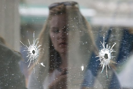 &lt;p&gt;A woman looks at the bullet holes Saturday on the window of IV Deli Mark where Friday night's mass shooting took place by a drive-by shooter in Isla Vista, Calif.&lt;/p&gt;