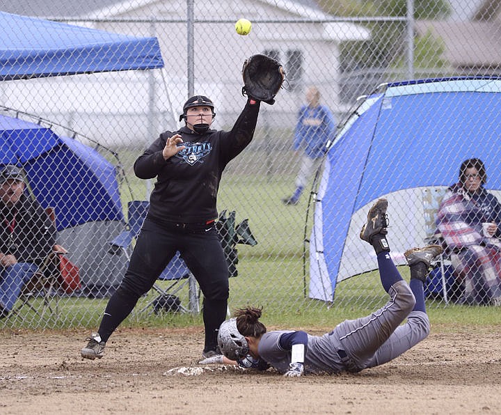 &lt;p&gt;Third baseman Amanda Morency watches a ball into her glove as an Anaconda player dives for the base during Ronan&#146;s game against Anaconda Saturday morning.&lt;/p&gt;