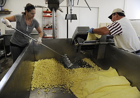&lt;p&gt;Diane Roeder, left, and Bob Stryk shred slabs of cheese curd on April 25 at the Stryk Jersey Farm in Schulenberg, Texas.&lt;/p&gt;