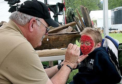 Photos by Nick Ianniello Vendor Dale Archer helps St. Regis second-grader Tristan Carman look like his favorite cartoon character at the St. Regis Flea Market Sunday afternoon. Archer has been a vendor at the fair for two years now and this is his first year doing face painting. Archer said the flea market had a fun, family atmosphere.