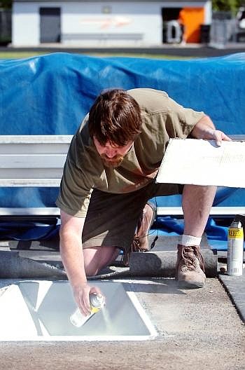 BIll Thompson repaints the pole vault box at Legends Stadium on Wednesday morning. Some 900 athletes are expected for the state track meet at Legends on Friday and Saturday.