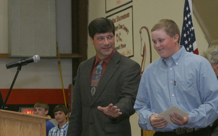 &lt;p&gt;Thom Chisholm shares a light moment with a student as he accepts his graduation certificate during the eighth grade commencement ceremony on Wednesday.&lt;/p&gt;