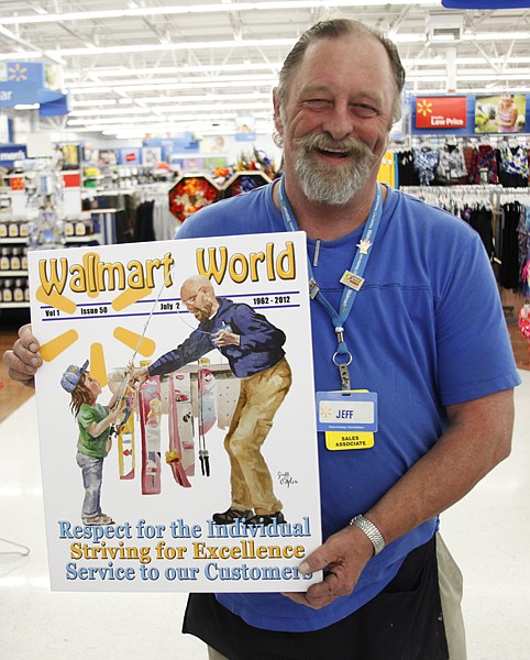 <p>WalMart sales associate Jeff Nobles, of Polson, holds up his winning painting for an employee art contest sponsored by WalMart, in celebration of their 50th anniversary. Nobles, one of fifteen winners, painted the art piece during his lunch breaks.</p>