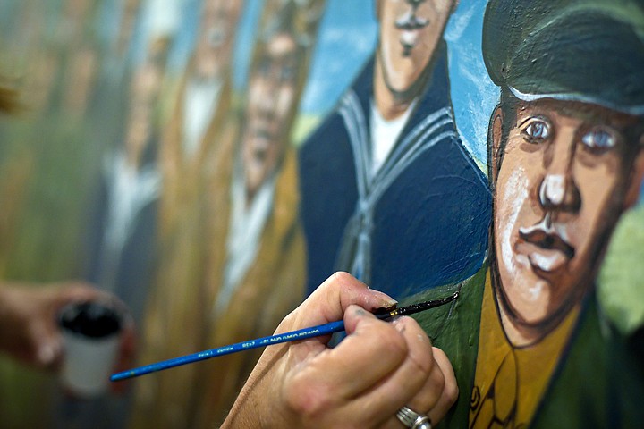 &lt;p&gt;Linda Fabrizius paints details onto a uniform of one of the 23 war veterans represented in a mural that will be unveiled Monday during a ceremony at the Post Falls City Hall.&lt;/p&gt;