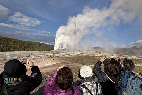 &lt;p&gt;In this photograph taken May 21 in Yellowstone National Park, Mont., tourists photograph Old Faithful erupting on schedule late in the afternoon. As the summer travel season kicks off this Memorial Day weekend, many people may take one look at the price of an airplane ticket or a gallon of gas and decide to put off their dream vacation for one closer to home and closer to nature.&lt;/p&gt;