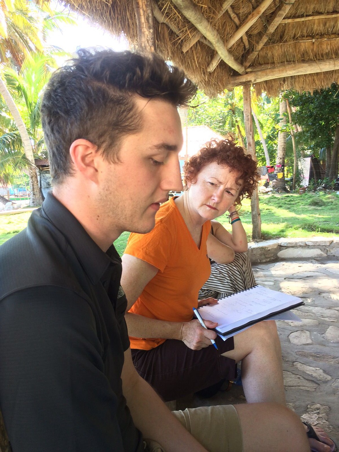 <p>Nic Johnson sits with his former French teacher from Coeur dAlene Charter Academy, Lynda LeBlanc, in front of the AID Project office on the island of Ile-a-Vache in Haiti.</p>