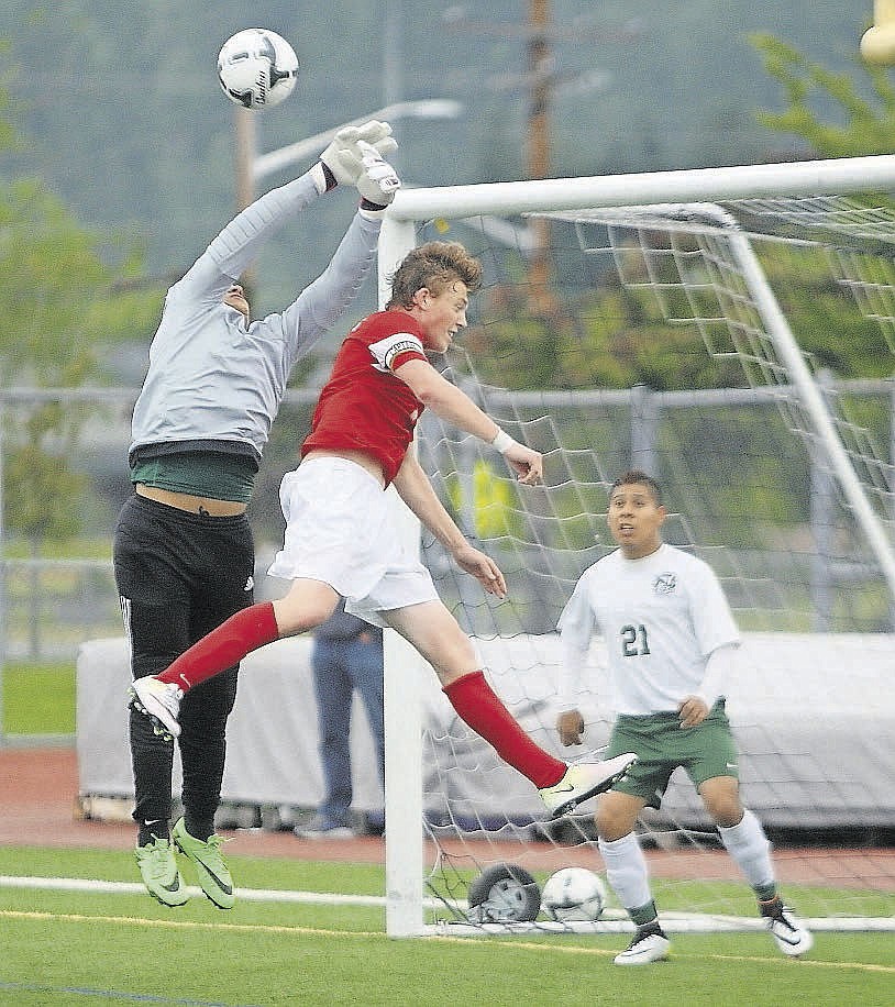 Quincy goaltender Johan Farias battles Atchbishop Murphy striker for a ball during a corner kick in Saturday's 2A state soccer championship at Sunset Chev Stadium in Sumner.