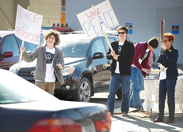 Josh Schott, left, and others are pictured at a peace rally on March 19 in downtown Whitefish.