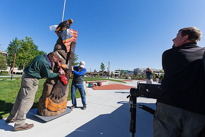 &lt;p&gt;Bill Greenwood, parks superintendent for the City of Coeur d&#146;Alene, left, and Fred McMurray position a sculpture made from McEuen Park&#146;s original Freedom Tree as artist Jeff May, far right, operates a lift Thursday near the new dedicated tree at the park. The original tree was planted near McEuen Park in an effort to stop development of Tubbs Hill and was rededicated in 1972 for McMurray, a prisoner of war. The sculpture, that includes a flag, a pair of eagles and the words &#147;Freedom&#148; and &#147;Return with Honor&#148; was completed by May in about two months.&lt;/p&gt;