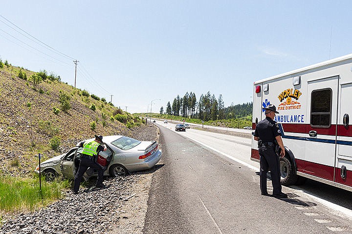 &lt;p&gt;Shane Grady, a trooper with the Idaho State Police, left, investigates a single-car rollover crash on U.S. 95 near Fighting Creek on Friday. The vehicle came to rest in the ditch alongside the northbound highway lanes. Minor injuries were reported.&lt;/p&gt;