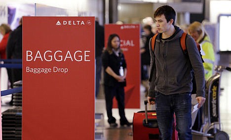 &lt;p&gt;In this photo taken Tuesday, March 24 travelers walk toward the baggage drop area for Delta airlines at Seattle-Tacoma International Airport in SeaTac, Wash. This summer travel season, Delta plans to preload carry-on bags above passengers? seats on some flights.&#160;&lt;/p&gt;