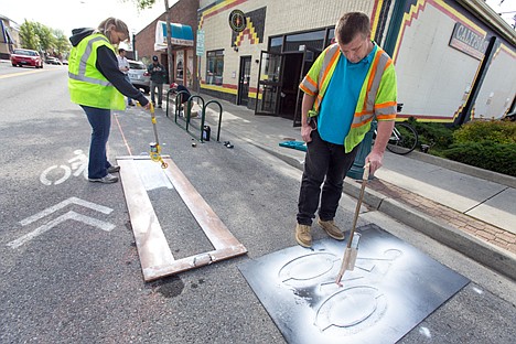 &lt;p&gt;GABE GREEN/Press&lt;/p&gt;&lt;p&gt;Terry Leigh, right, and Beth Taylor from the street department spray paint lines and symbols onto the road where the city of Coeur d&#146;Alene has put in a new temporary on-street bike corral on Lakeside Avenue. The final corral will have art work on either side. Two more corrals will be installed at a later date but it was decided that one should be opened in recognition of national bike to work week.&lt;/p&gt;